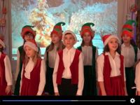 zespól Amiko w strojach elfów i mikołajów śpiewający świąteczne posenki